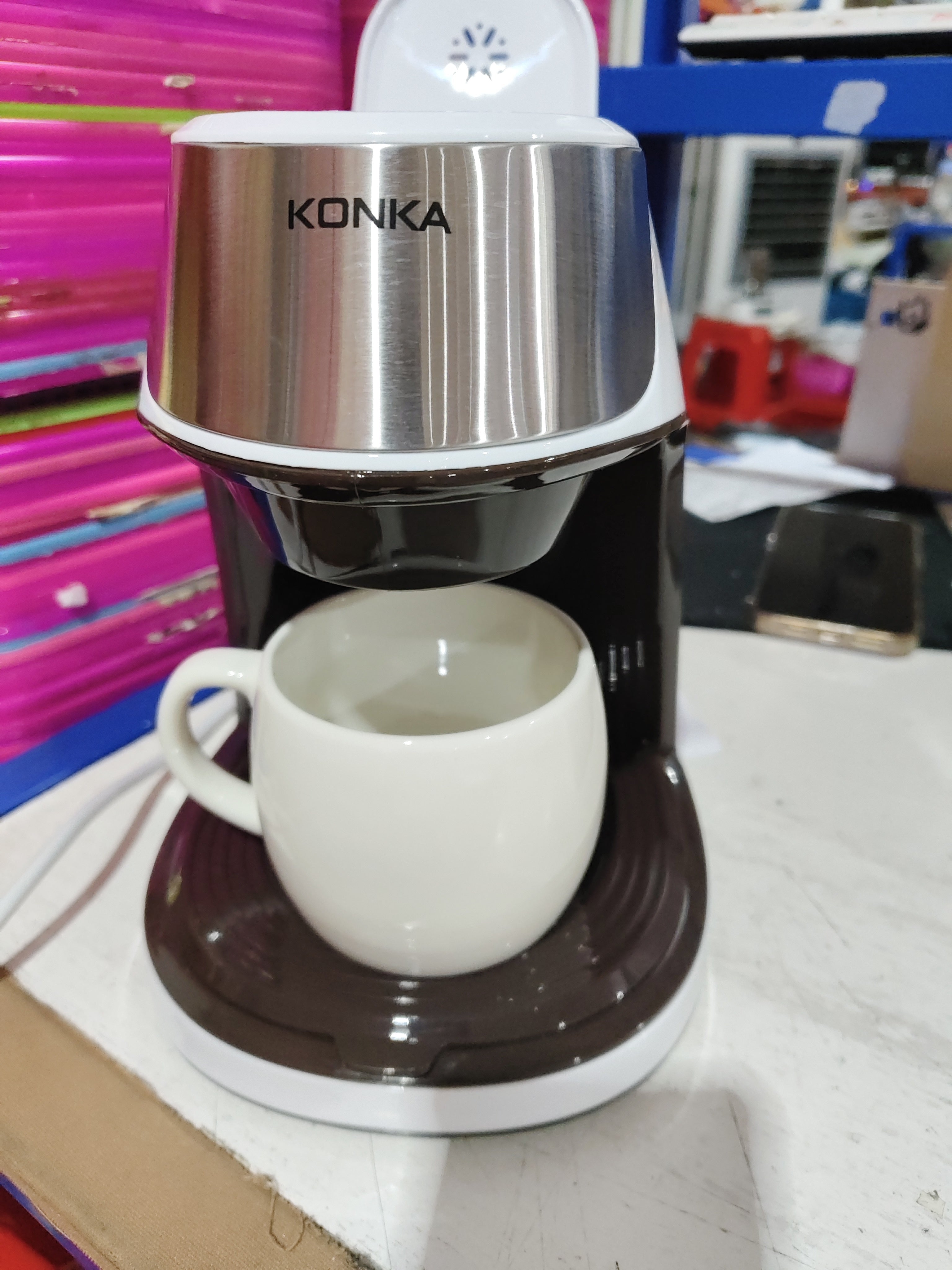 Compact Fully Automatic Home Coffee Maker brewing coffee at home with a cup on the table.